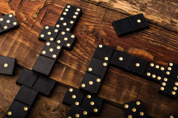 Playing dominoes on a wooden table. Domino effect. Copy space