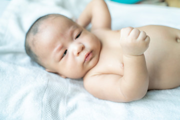 Adoraable infant baby boy lying on white blanket
