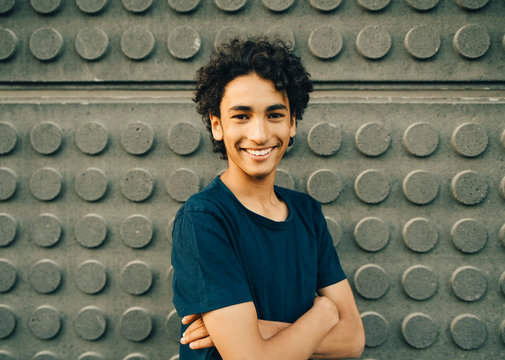 Portrait of smiling teenage boy against wall