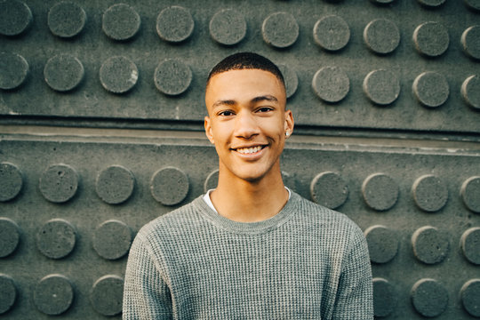 Portrait of smiling teenage boy against wall