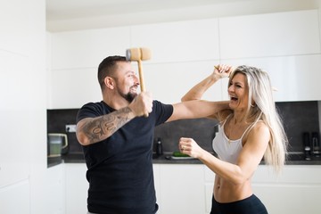 Husband and wife confrontation in kitchen - Having a fun together.