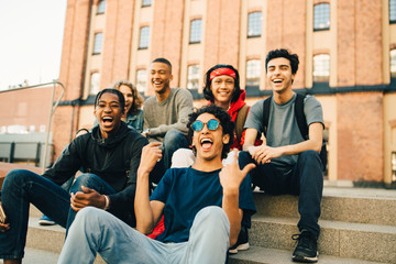 Group of male friends sitting on steps in city