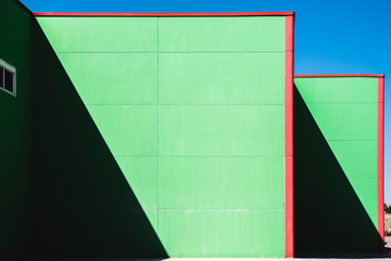 Fototapeta premium Pared verde de nave con sombras geométricas.