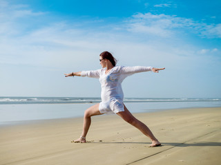 Young girl doing yoga on the Indian Ocean