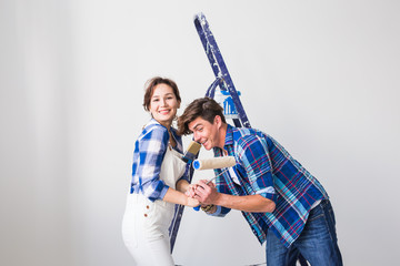 Teamwork, renovation and repair concept - Portrait of funny couple doing redecoration in apartment
