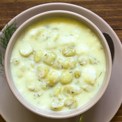 Traditional Hungarian Piszkeszosz or Piszkemartas, a cooked gooseberry, milk and egg dessert, served in bowl, photographed overhead on dark wood with natural light