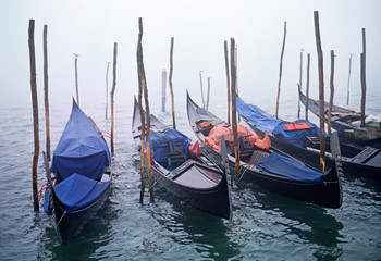 Fototapeta na wymiar Gondolas moored in the mist on the Grand Canal Venice