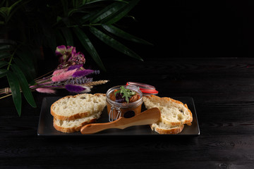 Japanese duck pate with warm ciabatta on a black tray on a dark wooden background © Said Ramazanov