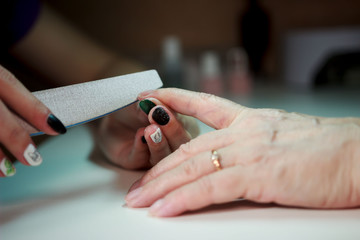 Fototapeta na wymiar manicure for an elderly woman. the beauty of old age. age skin