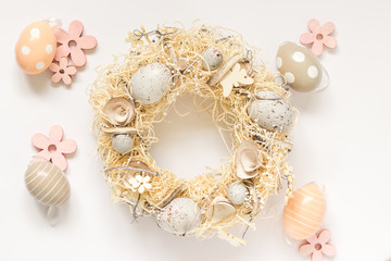 Spring wreath with easter egg decorations, top view, white background