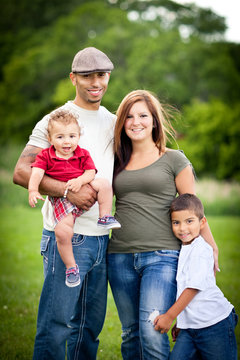 Happy Young Family Standing Together Outside - Color Portrait