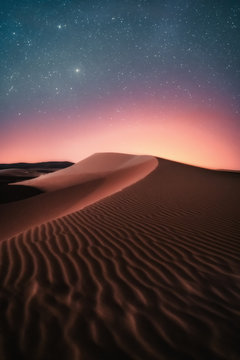 Magic night in the Sahara Desert under incredible starry sky. Travel adventure in Merzouga, Morocco. Long exposure by night