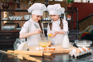 funny girls kids are preparing the dough in the kitchen.