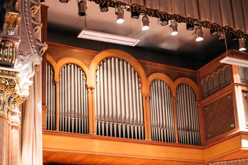 Musical organ with gray tubes and beautiful columns from the side