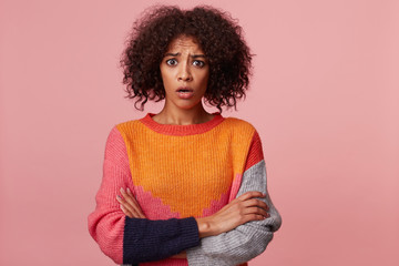 Young pretty brunette girl with afro hair looks shocked, stupefied, dropped jaw,stares in camera,...