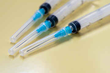 Several syringes on a yellow background. Vaccinations.