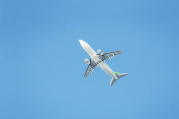 Passenger airplane isolated against the blue sky. Front view.