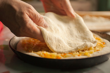 Woman cooks a pie with cabbage
