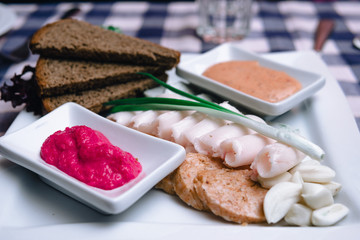 Traditional Ukrainian dish on a white plate. lard, garlic, forshmak, horseradish, garlic sauce. baking and healthy spices. black bread. delicacy