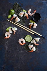 Fototapeta na wymiar Shrimp sushi with lime on a dark blue surface