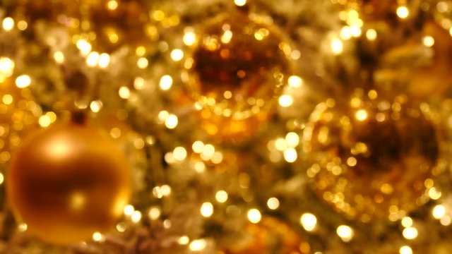 Gold Christmas baubles with bokeh of party lights