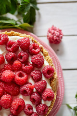 Top view of a fresh cheesecake with raspberries