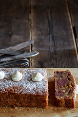Pound cake with icingsugar and icing on wooden board