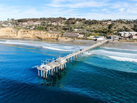 Aerial View Of The Scripps Pier Institute Of Oceanography, La Jolla, San Diego, California, USA. Research Pier Used To Study Ocean Conditions And Marine Biology.  Pier With Luxury Villa On The Coast.