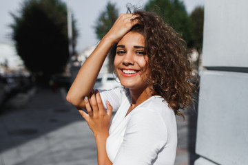 Portrait of smiling european woman with brunette curly hair