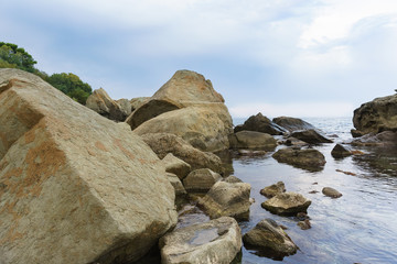Fototapeta na wymiar Huge boulders on the black sea. Boulders on the children's beach in Alupka. Twilight. Crimea