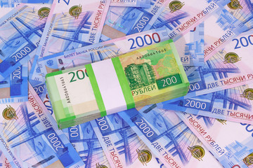 New Russian rubles: a pack of two-ruble banknotes in a Bank package on the background of two thousand bills. Investment