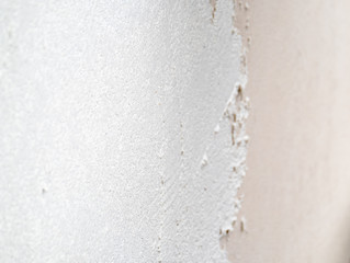 Construction worker plastering and smoothing concrete wall with cement