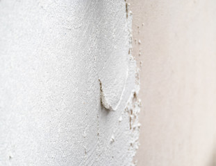 Construction worker plastering and smoothing concrete wall with cement
