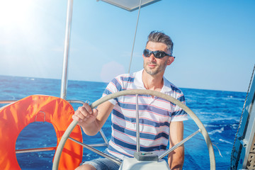 Young man sailing yacht. Holidays, people, travel