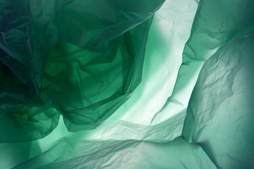Plastic bag. Polyethylene may use as background. Template for card, poster, banner design. Dark green background. Space for your own text and design. Green gradient background.