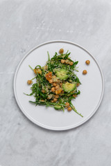 Quinoa salad on white plate on marble table
