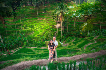 Happy couple walking at the rice terraces. Traveling at Bali.