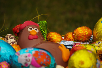 Fototapeta na wymiar Chocolate chicken in basket next to easter eggs.