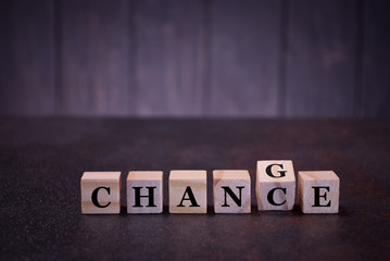 The word change chance on wooden cubes, on a dark background, symbols signs