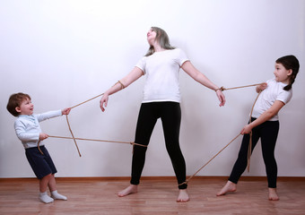Children pull mom in different directions. Mother of many children. hyperactive children. Tired...