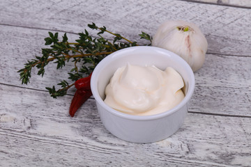 Mayonnaise sauce in the white bowl served thyme and garlic