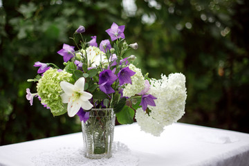 a bouquet of garden flowers stands in a vase