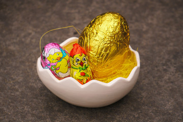 Chocolate easter eggs and figures in basket