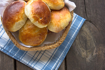 Traditional russian pastry - piroshki on wooden table.