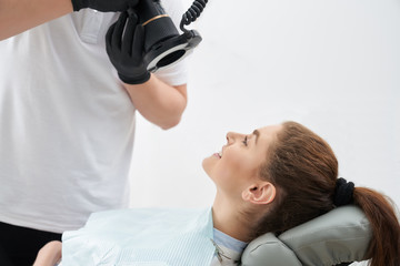 Man taking photo of teeth after whitening in dental office