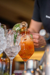 female bartender preparing aperol cocktail in a cocktail bar