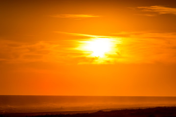 Fototapeta na wymiar Golden sunset on the beach with the sun over the beach