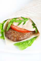 Wrap sandwich with meat steak, cheese, tomato and greenery on white