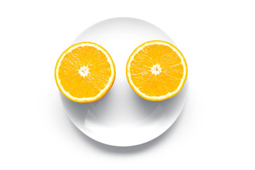 Two ripe orange parts on a round plate