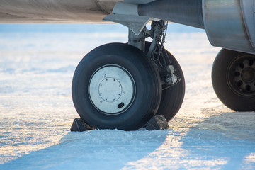 chassis airplane close-up in winter in snow. Close-up of chassis of passenger airliner in the snow...
